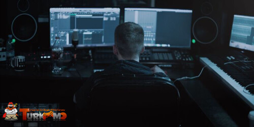 a-guy-at-a-computer-setup-with-a-microphone-speakers-and-two-monitors-best-voice-changer-softwares-for-use-with-discord.jpg