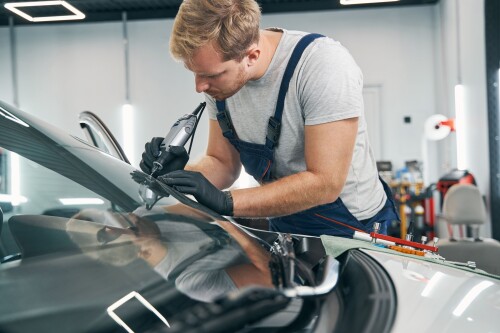 car-service-technician-checks-crack-on-car-windshield-closeup.jpg
