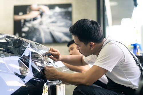 two-asian-car-film-protection-male-worker-installing-film-to-black-color-car-in-garage.jpg